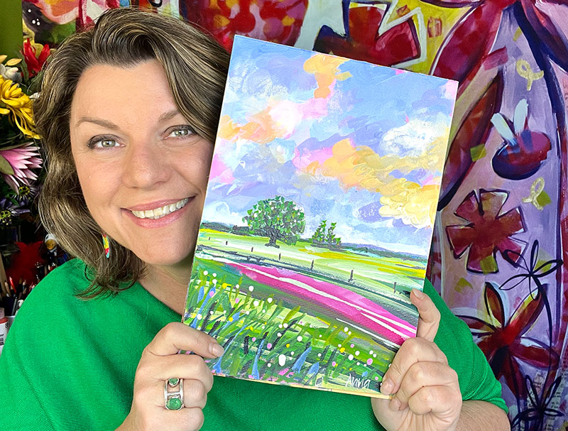 Anna holding 'Beautiful Day' painting